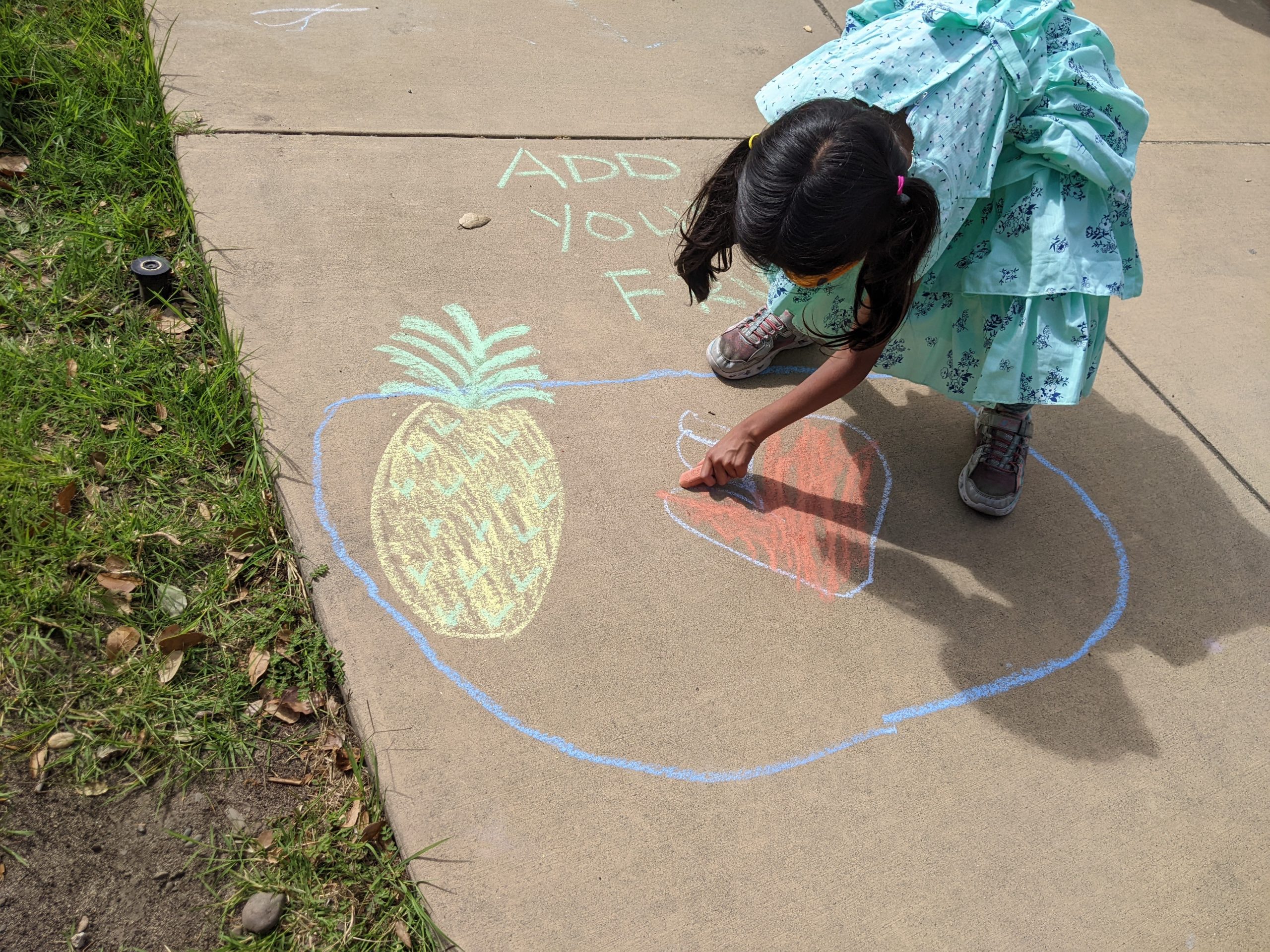 Girl drawing fruit with chalk